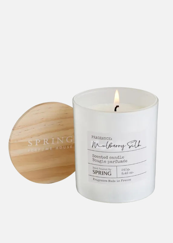 Candle with wooden lid labeled 'Spring' on a white background